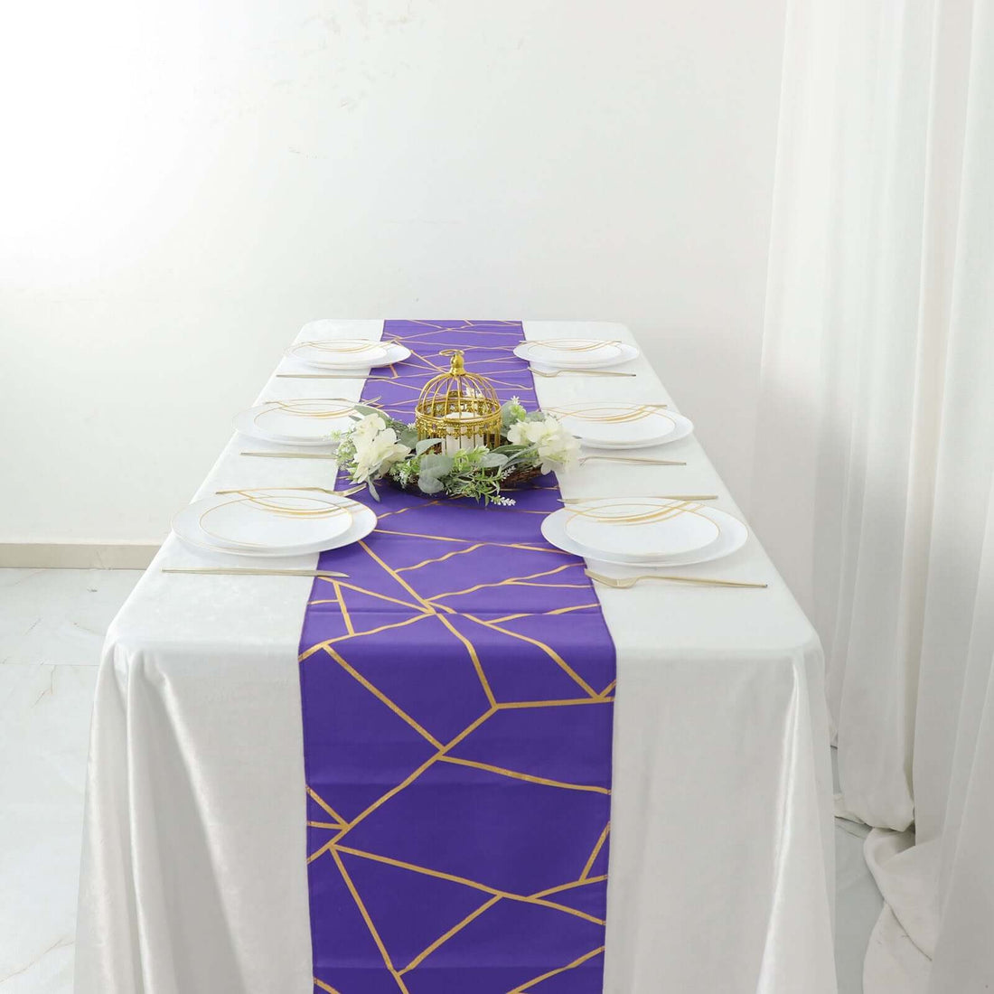 Elegant purple table runner with gold geometric design on a white table setting.