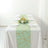 Table setting with mint green geometric runner and white plates.