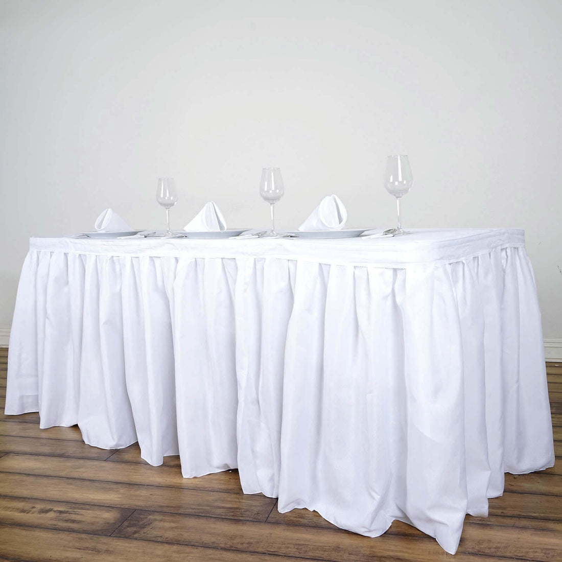 White table with elegant draping and glassware setup for formal dining.