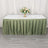 Elegant green table skirt with floral centerpiece and wine glasses.