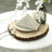 Elegant white napkin neatly folded on a rustic wooden table setting.