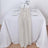 Neutral table runner on a white table setting with elegant glassware and flowers.