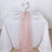 Elegant table setting with white tablecloth, pink runner, and floral centerpiece.
