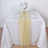 Yellow table runner on a white table set with plates and glasses.