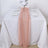 Peach table runner on a white dining table with plates and glasses.