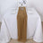 Elegant gold table runner on a white dining table setting with glassware and flowers.
