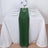 Green table runner on a white table set for dinner with glassware and plates.
