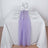 Purple table runner on a white table setting with glassware and flowers.