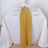 Yellow table runner on a white dining table set with plates and glasses.