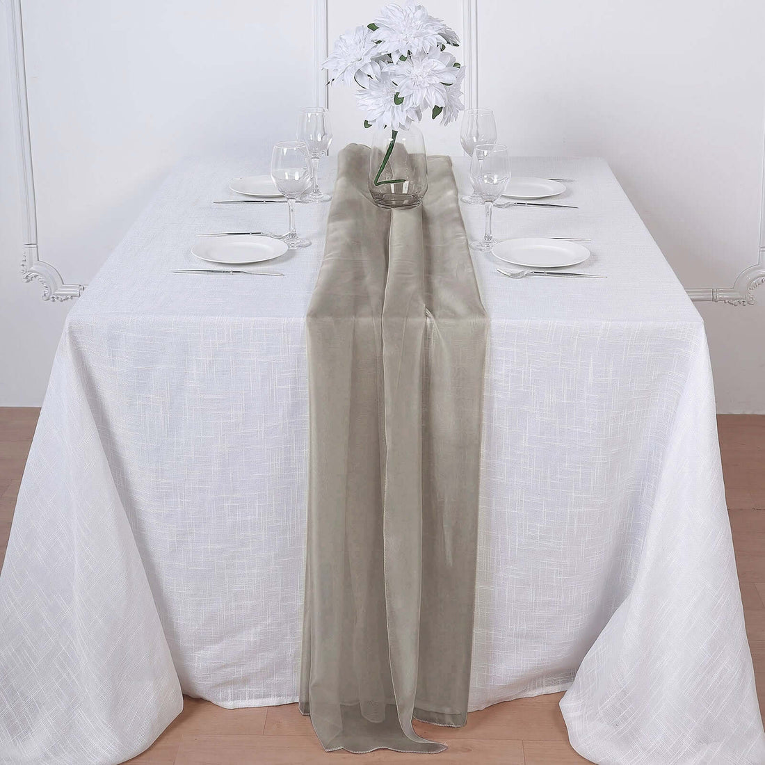 Elegant table setting with a sheer table runner and floral centerpiece.