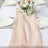 Elegant table setting with a floral centerpiece and soft fabric runner.