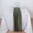 Elegant green table runner on a white table with floral centerpiece and dinnerware.