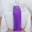Purple table runner on a white table with glassware and flowers.