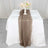 Elegant brown table runner on a white table with decorative plates and floral centerpiece.