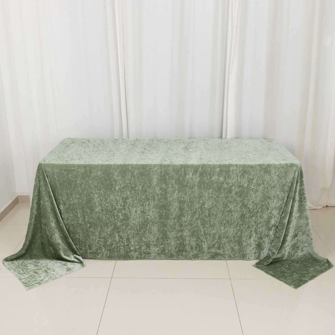 Green velvet tablecloth on a table against a plain backdrop.