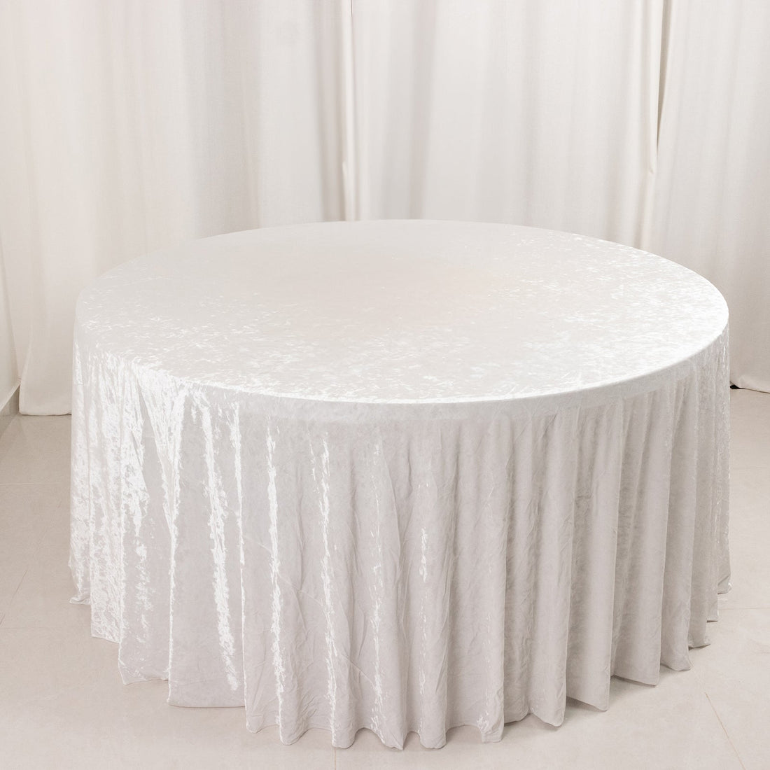 Round white table with elegant textured tablecloth