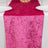 Pink velvet table runner on a dining table with white plates.