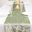 Elegant green table runner on a white dining table setting with glassware.