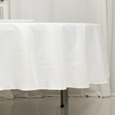 White tablecloth draped over a round table in a clean, elegant setting.