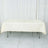 Cream tablecloth draped over a folding table in a studio setting.