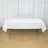 White tablecloth draped over a folding table in a bright room.