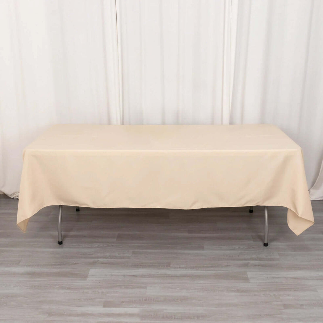 Beige table cover draped over a folding table.