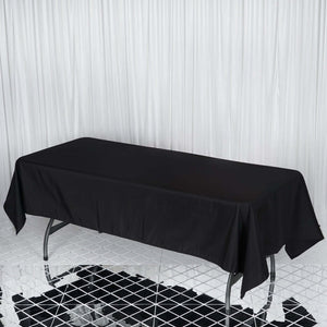 Black tablecloth draping over a rectangular table in a studio setting.