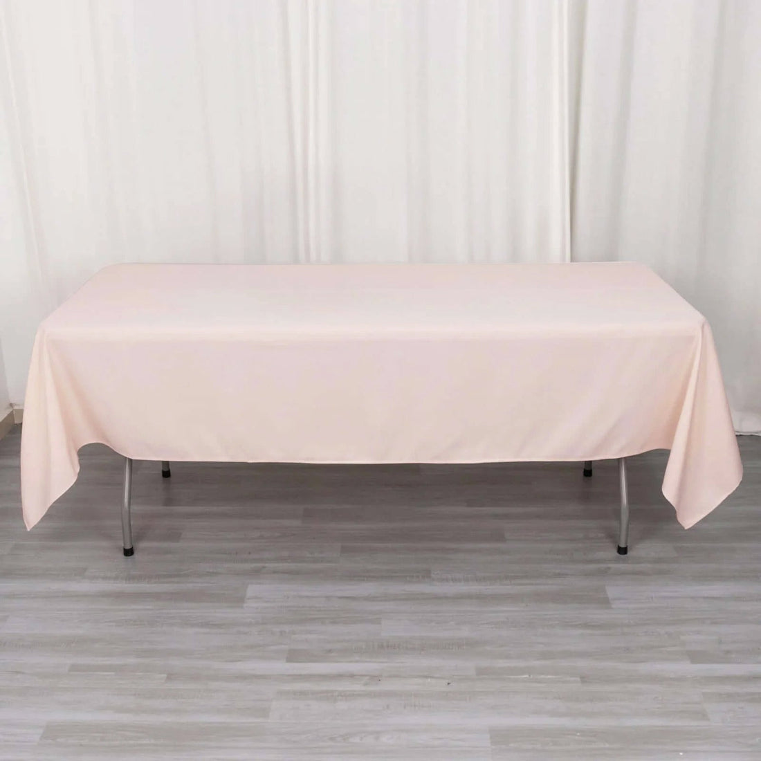 Pink tablecloth draped over a folding table in a studio setting.