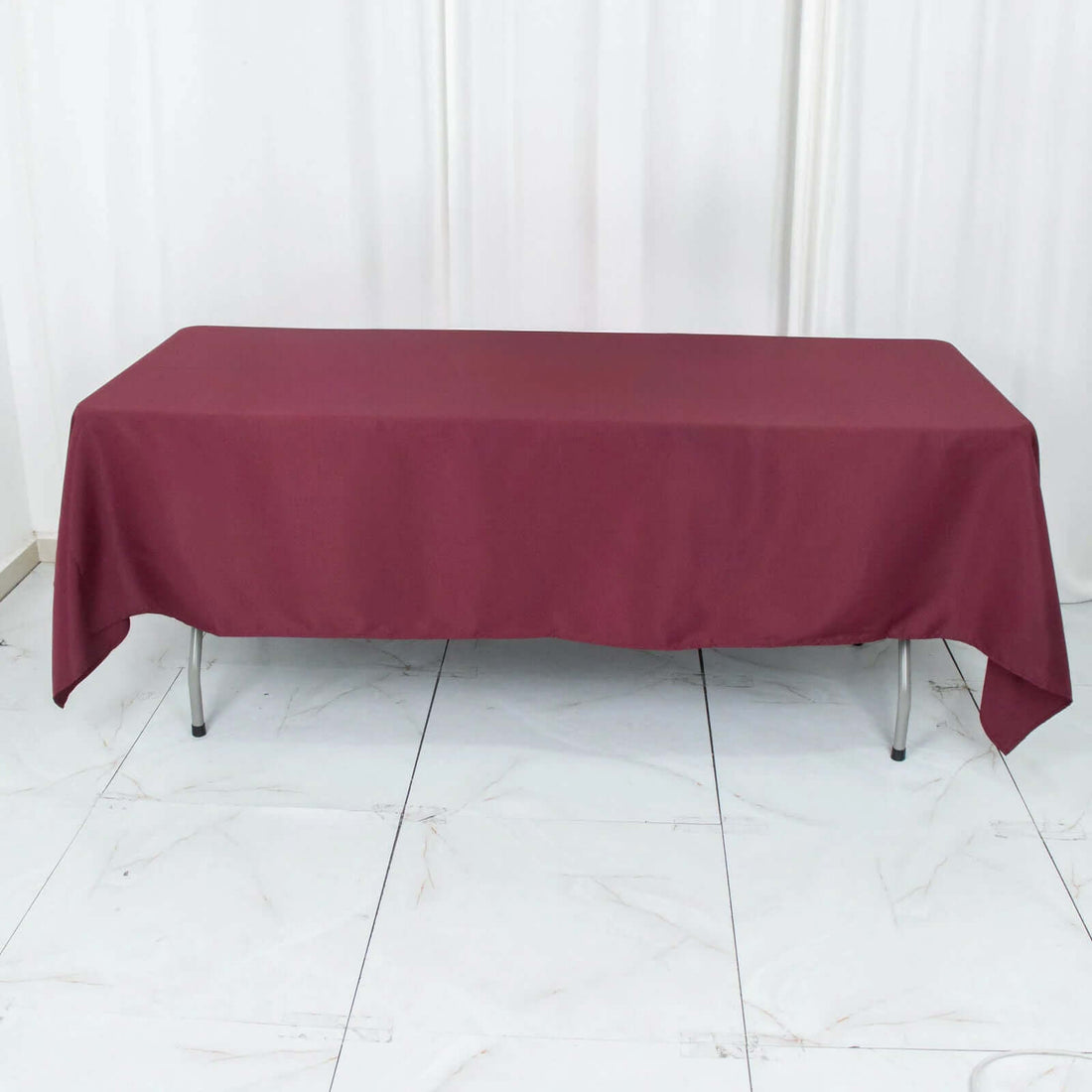 Burgundy tablecloth draped over a table in a studio setting