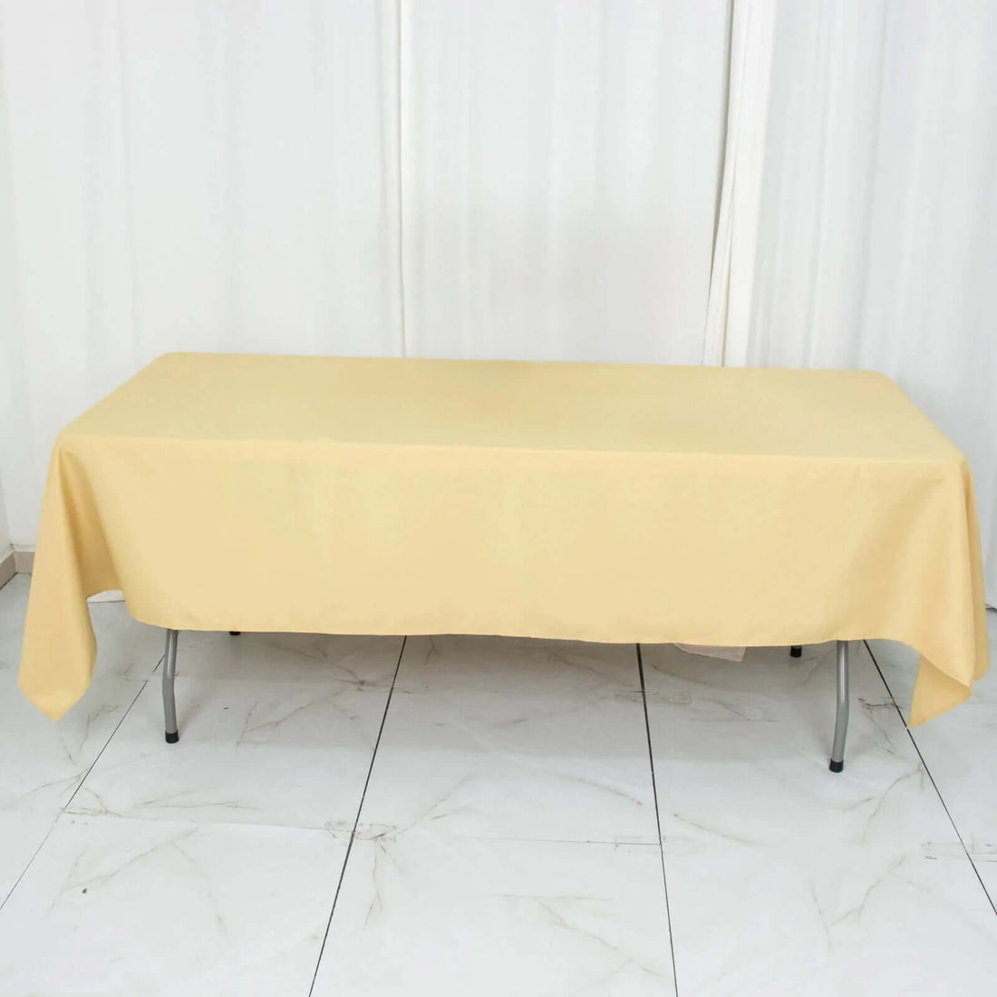 Yellow tablecloth draped over a rectangular table in a studio setting