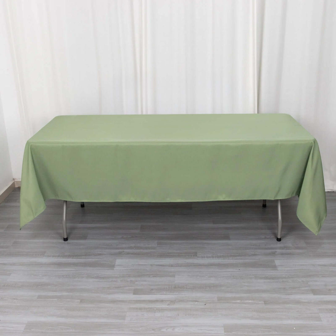 Green tablecloth draped over a table on a plain background.