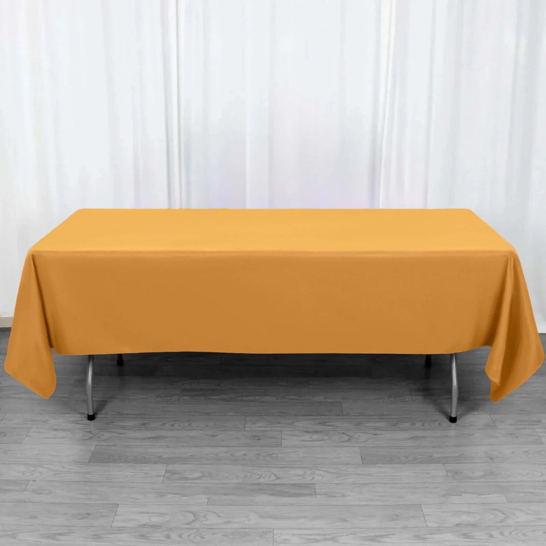 Orange tablecloth draped over a folding table in a studio setting.