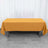 Orange tablecloth draped over a folding table in a studio setting.
