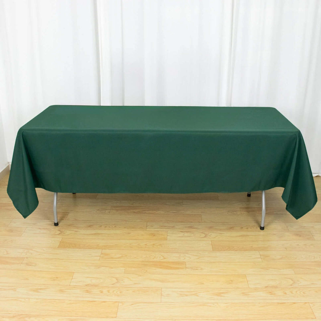 Green tablecloth draped over a folding table in a studio setting.