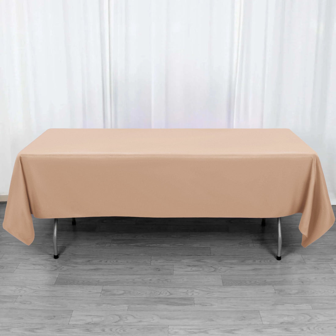 Beige tablecloth draped over a folding table in a studio setting