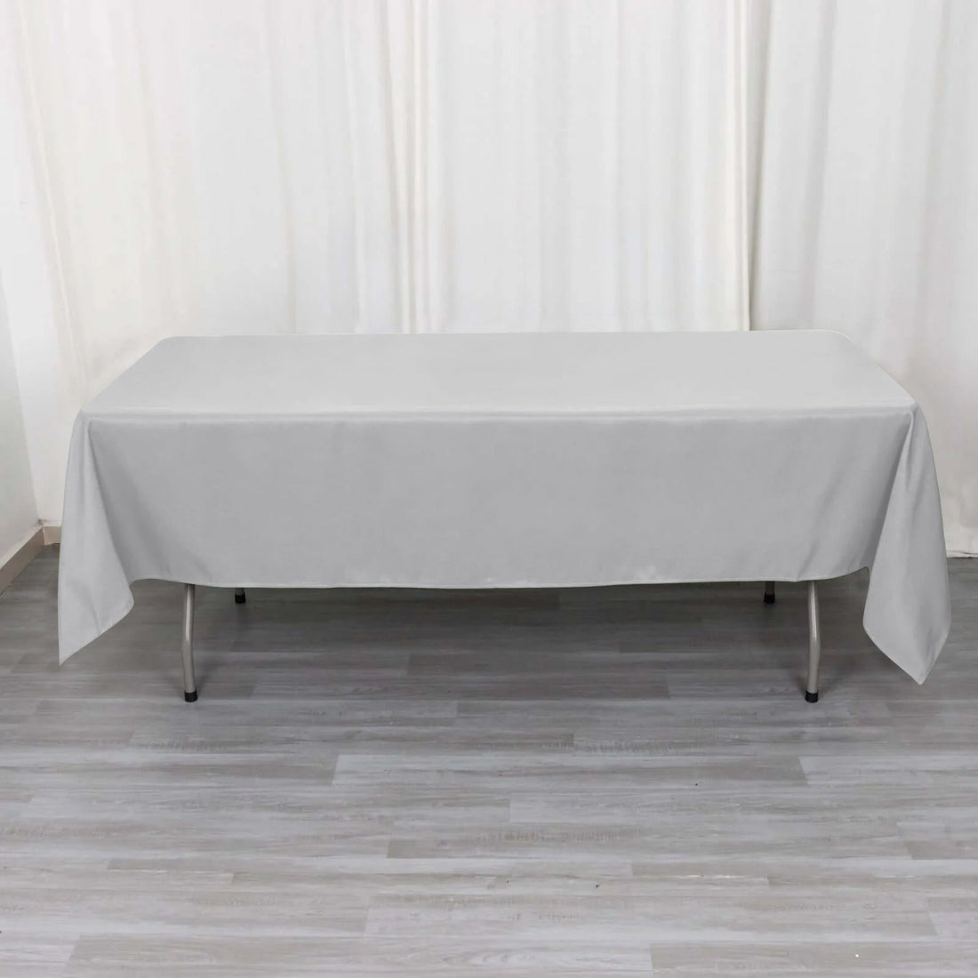 Gray tablecloth draped over a folding table in a studio setting.