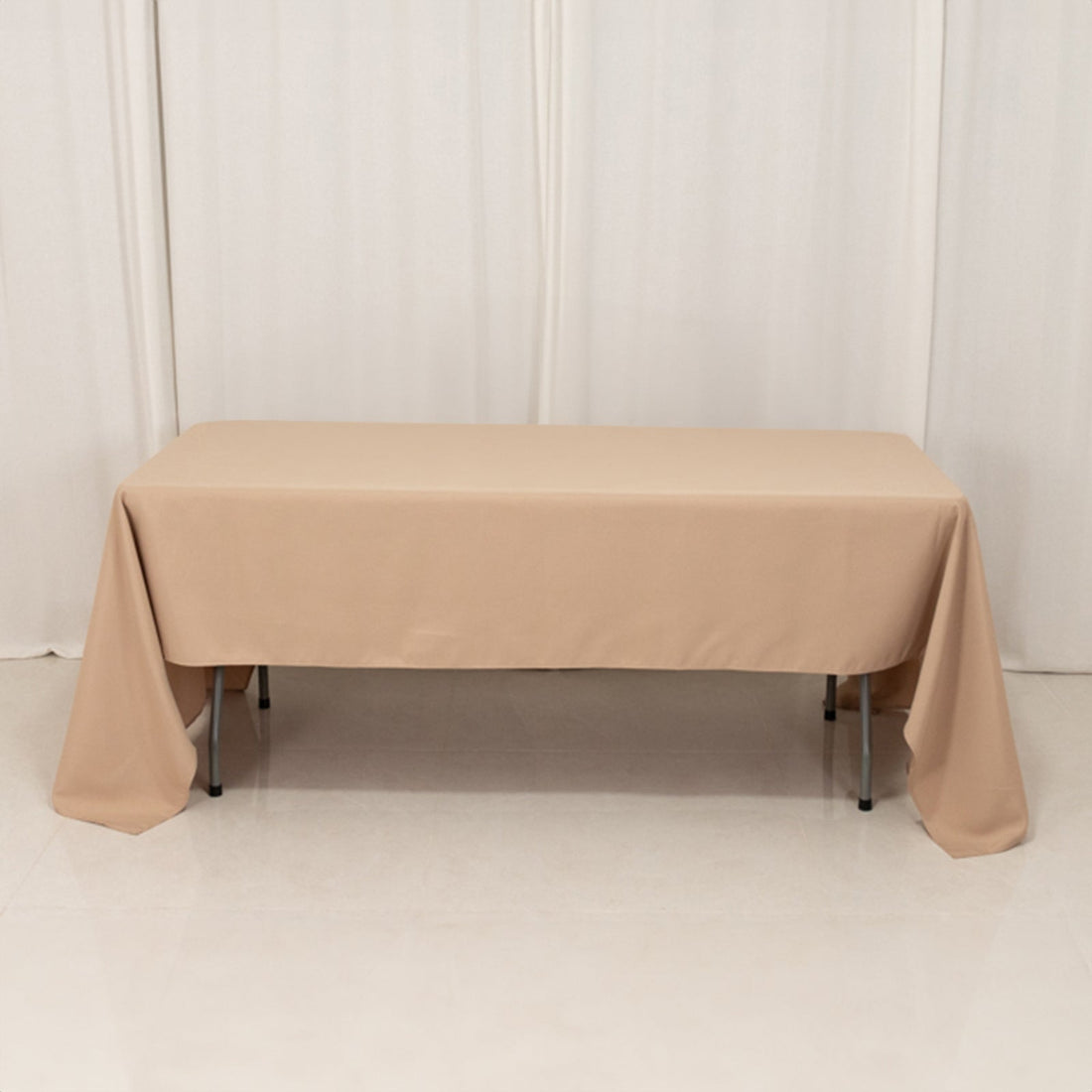 Beige tablecloth draped over a table in a studio setting.