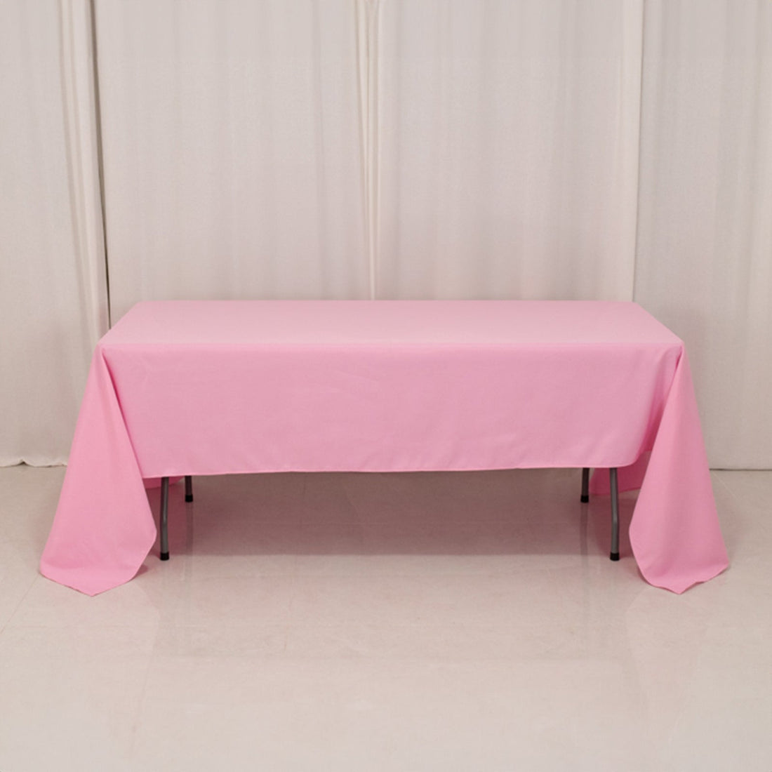 Pink tablecloth draped over a table in a studio setting.