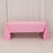 Pink tablecloth draped over a table in a studio setting.