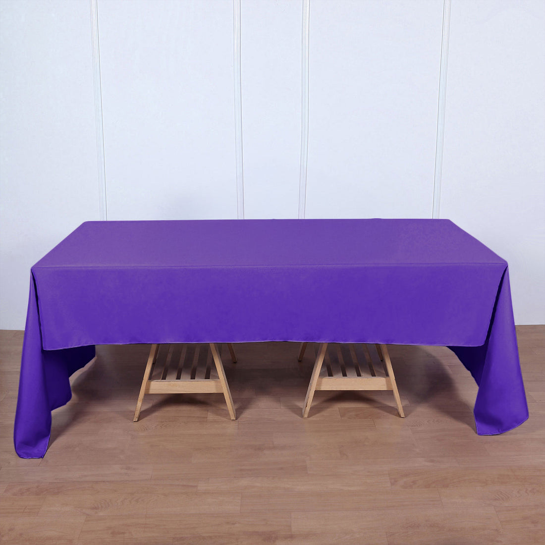 Purple tablecloth draped over a wooden table in a staged setting.