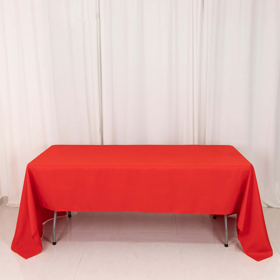 Red tablecloth draped over a table in a studio setting.