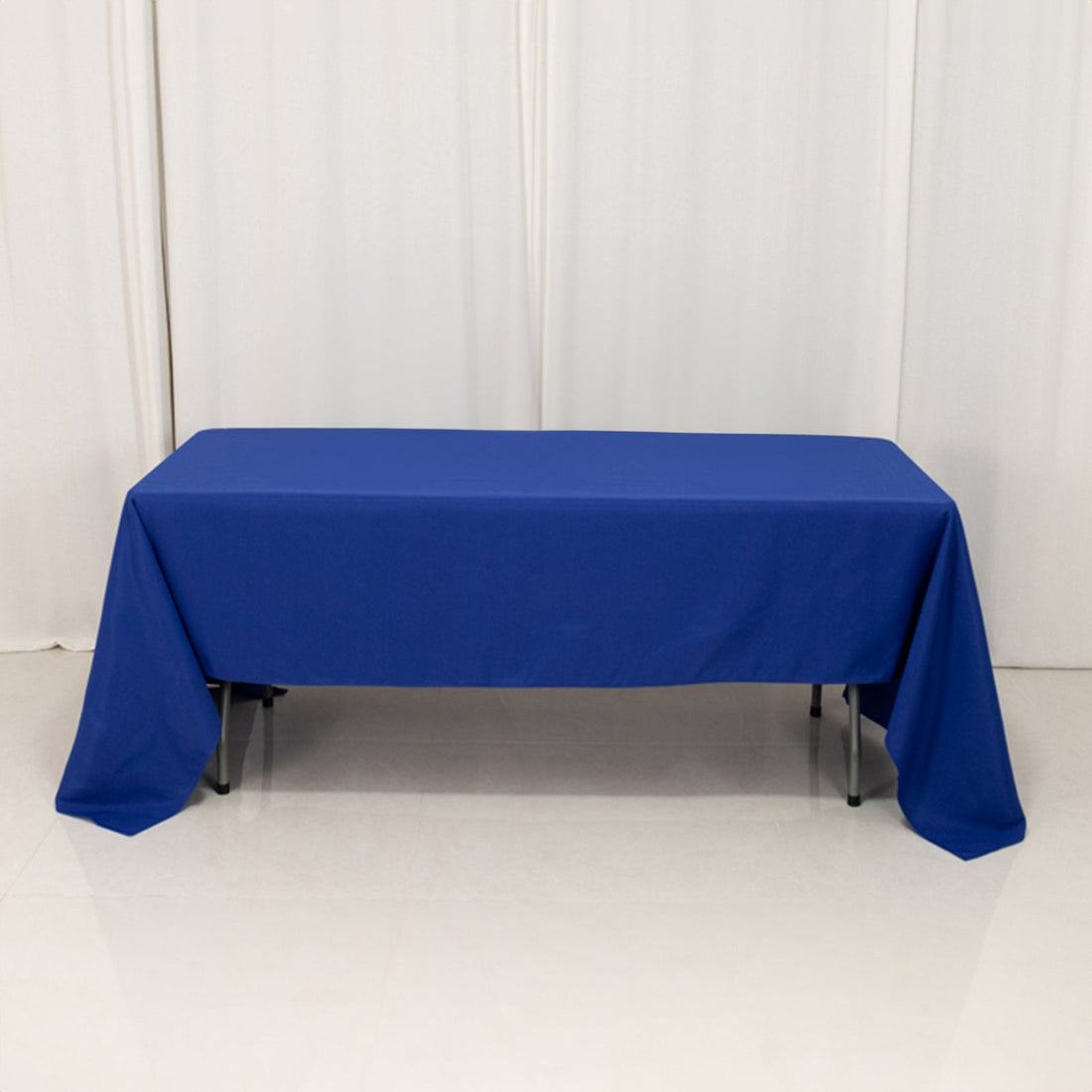 Blue tablecloth draped over a folding table in a studio setting.