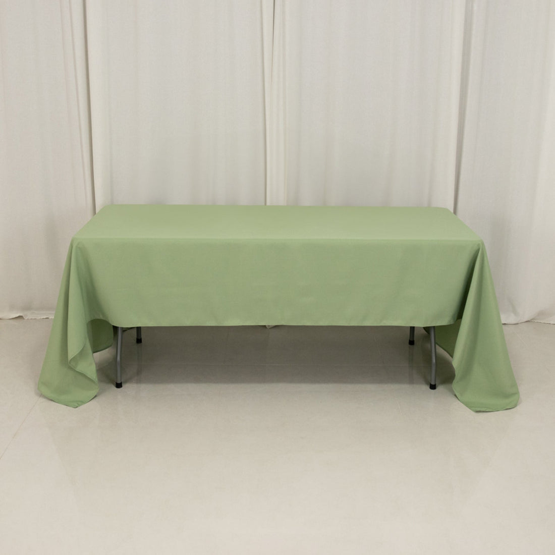 Green tablecloth draped over a table in a studio setting.