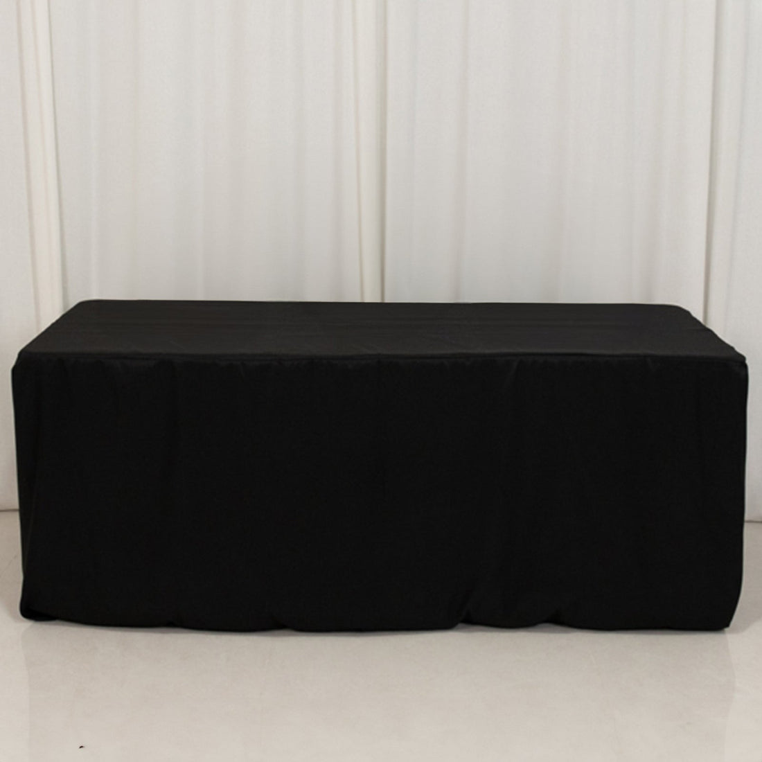 Black tablecloth draped over a rectangular table.