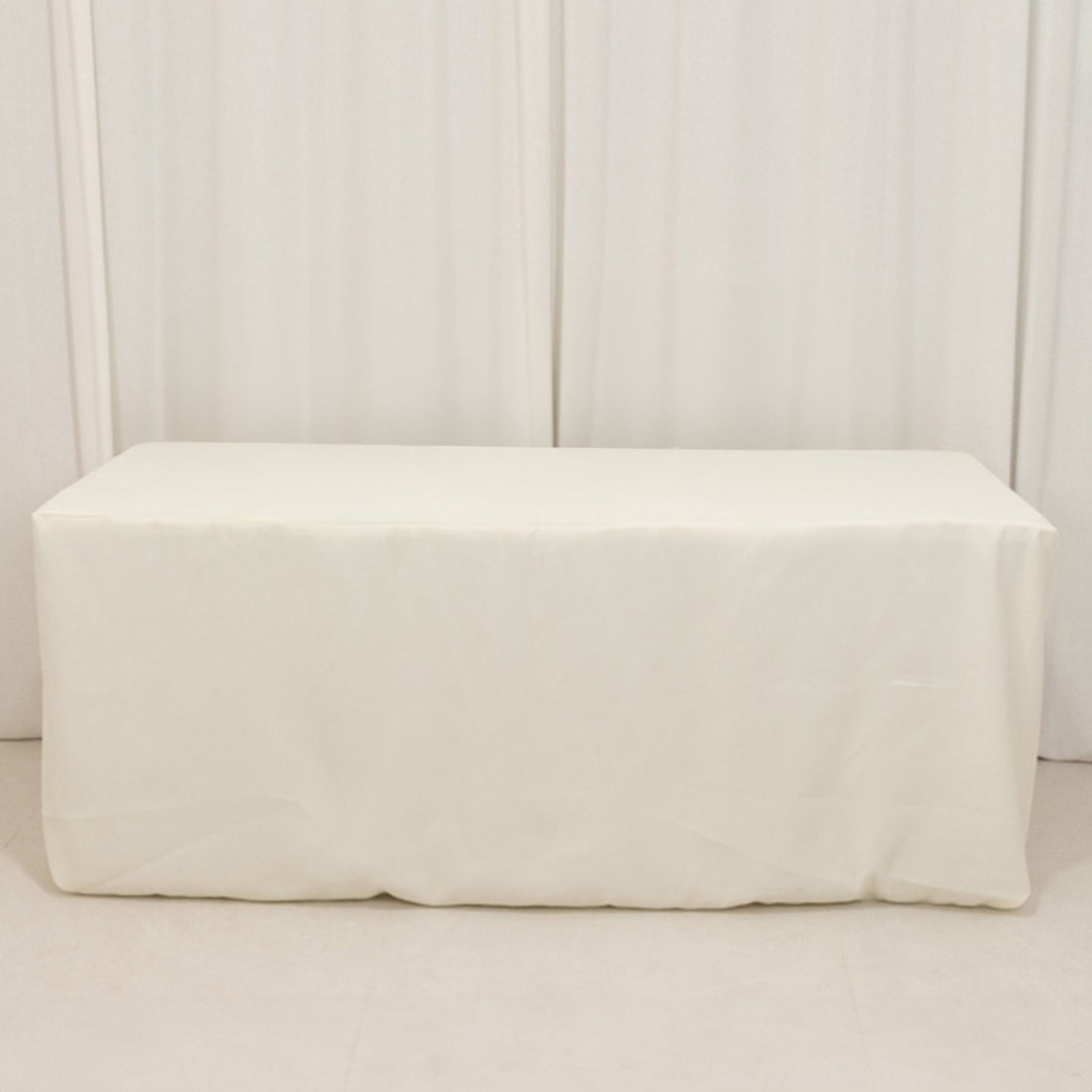 White table cover draped over a table in a studio setting.