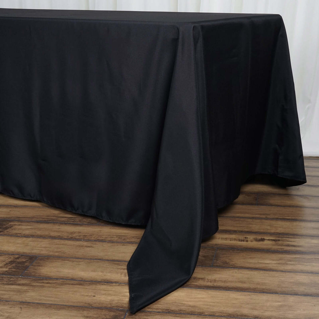 Black tablecloth draped elegantly over a wooden table surface.