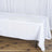 White tablecloth draped over a table against a plain backdrop