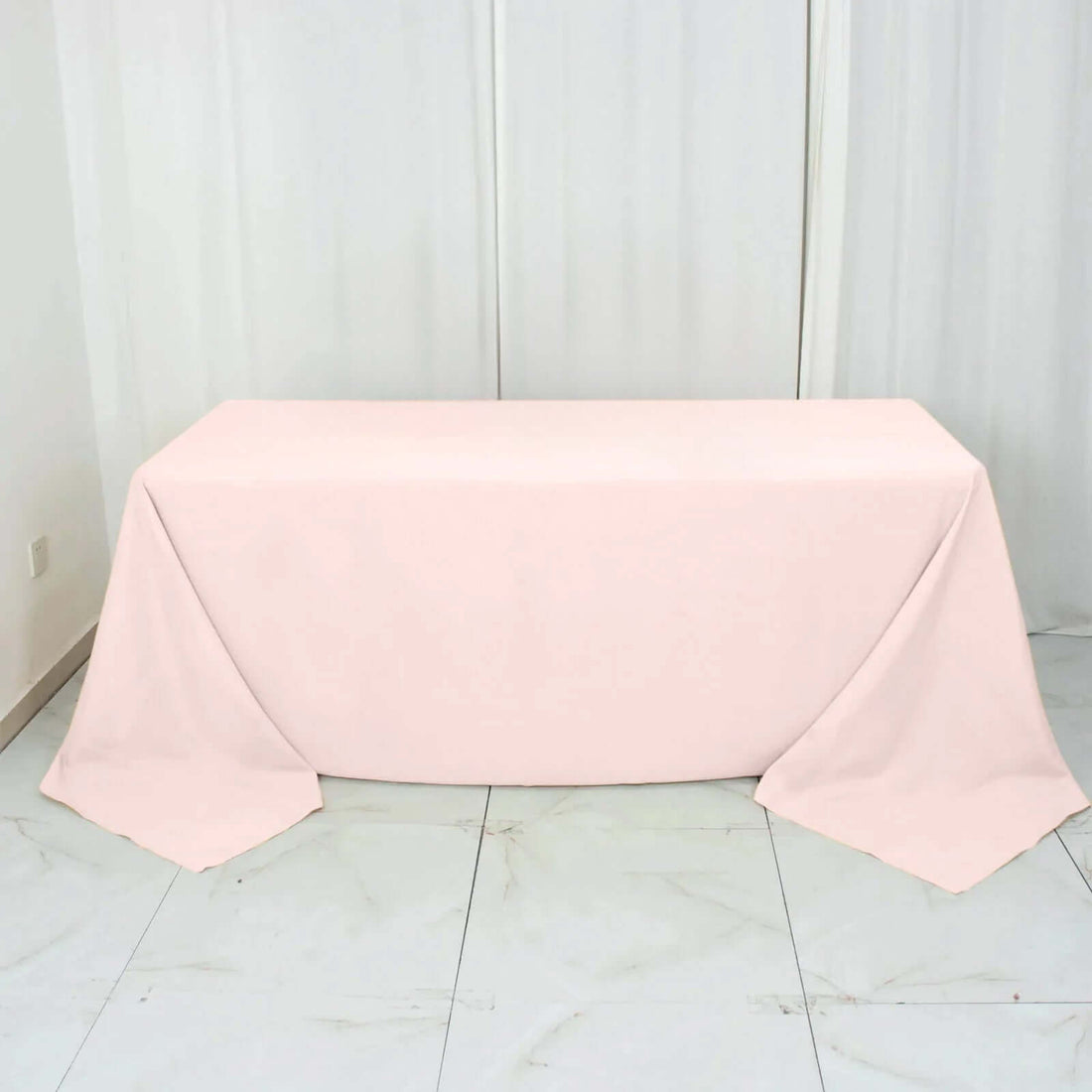 Pink tablecloth draped elegantly over a table in a studio setting.