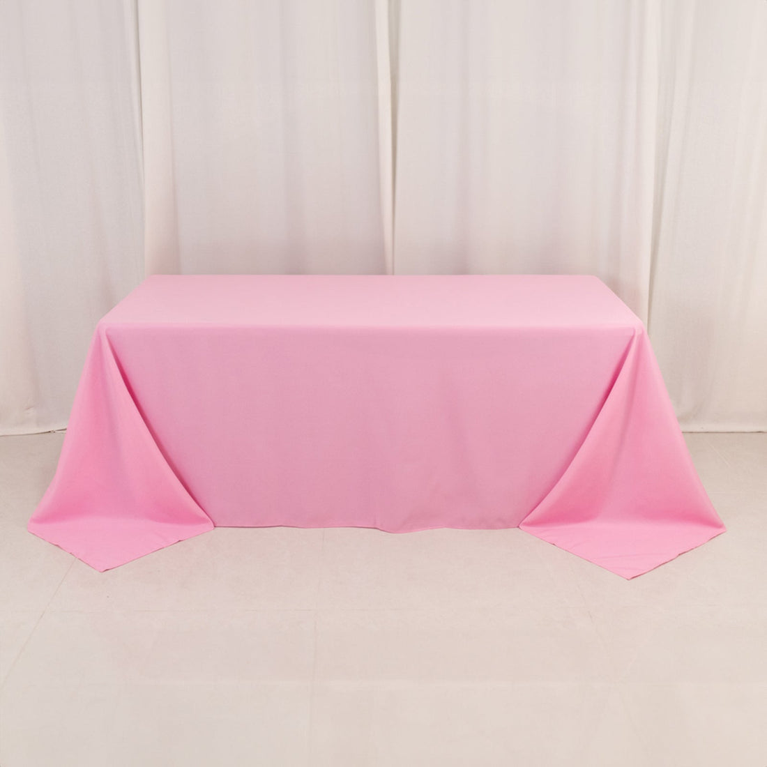 Pink tablecloth draped over a table against a plain background.