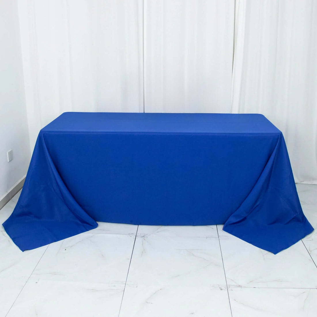 Blue tablecloth draping over a table in a clean, studio-style shot.